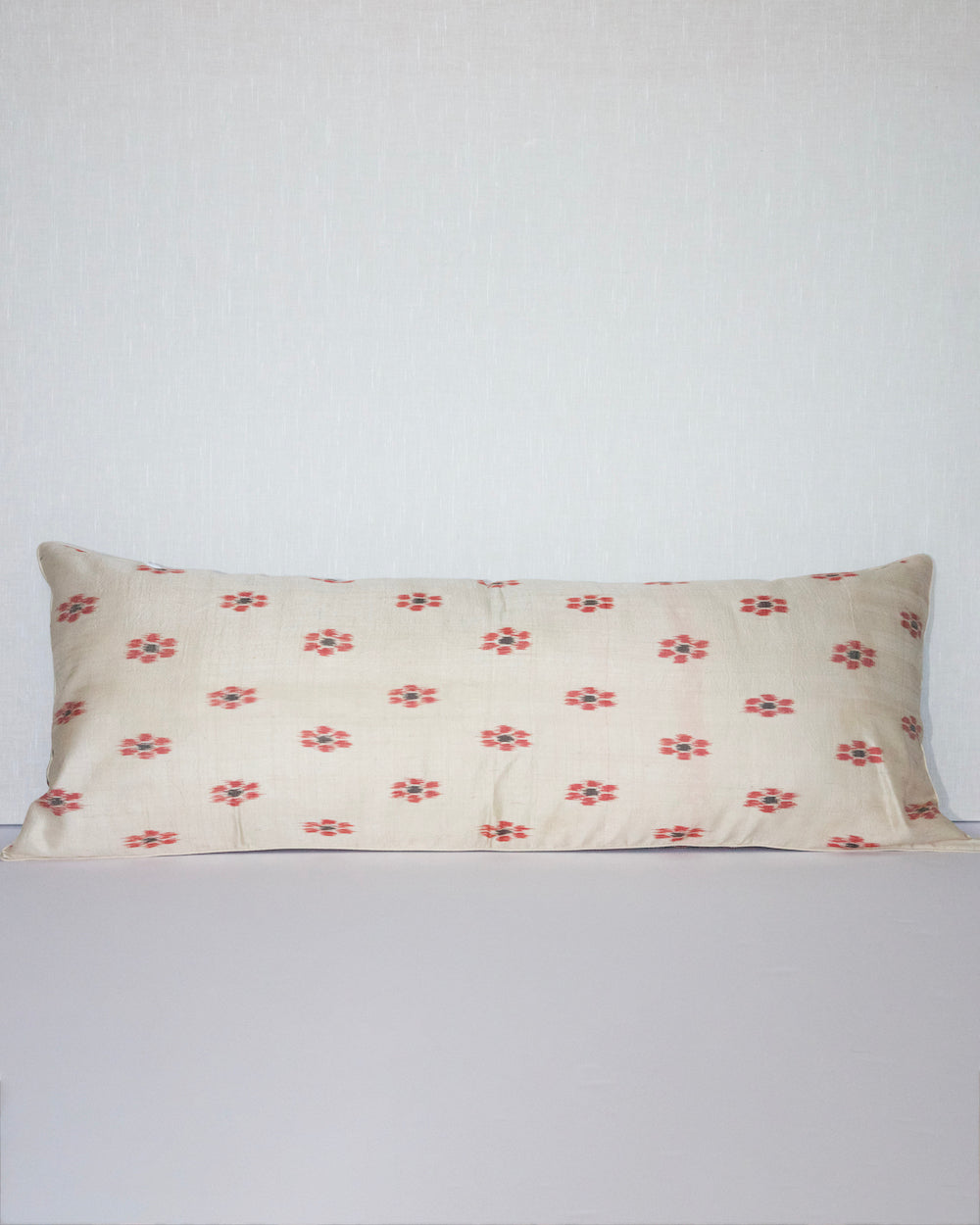 A unique lumbar pillow featuring intricate geometric and floral motifs in warm tones of red, teal, yellow, and beige, set against a black background. The handcrafted design offers a rich, bohemian aesthetic with vintage textile craftsmanship.