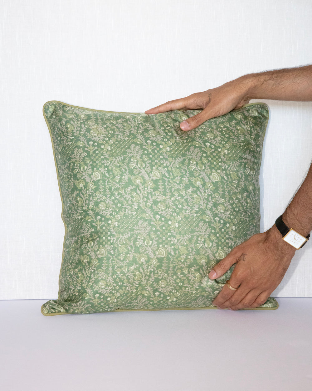A handcrafted 18x18 pillow cover in a soft green shade, featuring delicate floral and vine patterns in a subtle cream color. The intricate detailing and smooth fabric give the cushion an elegant, nature-inspired look.