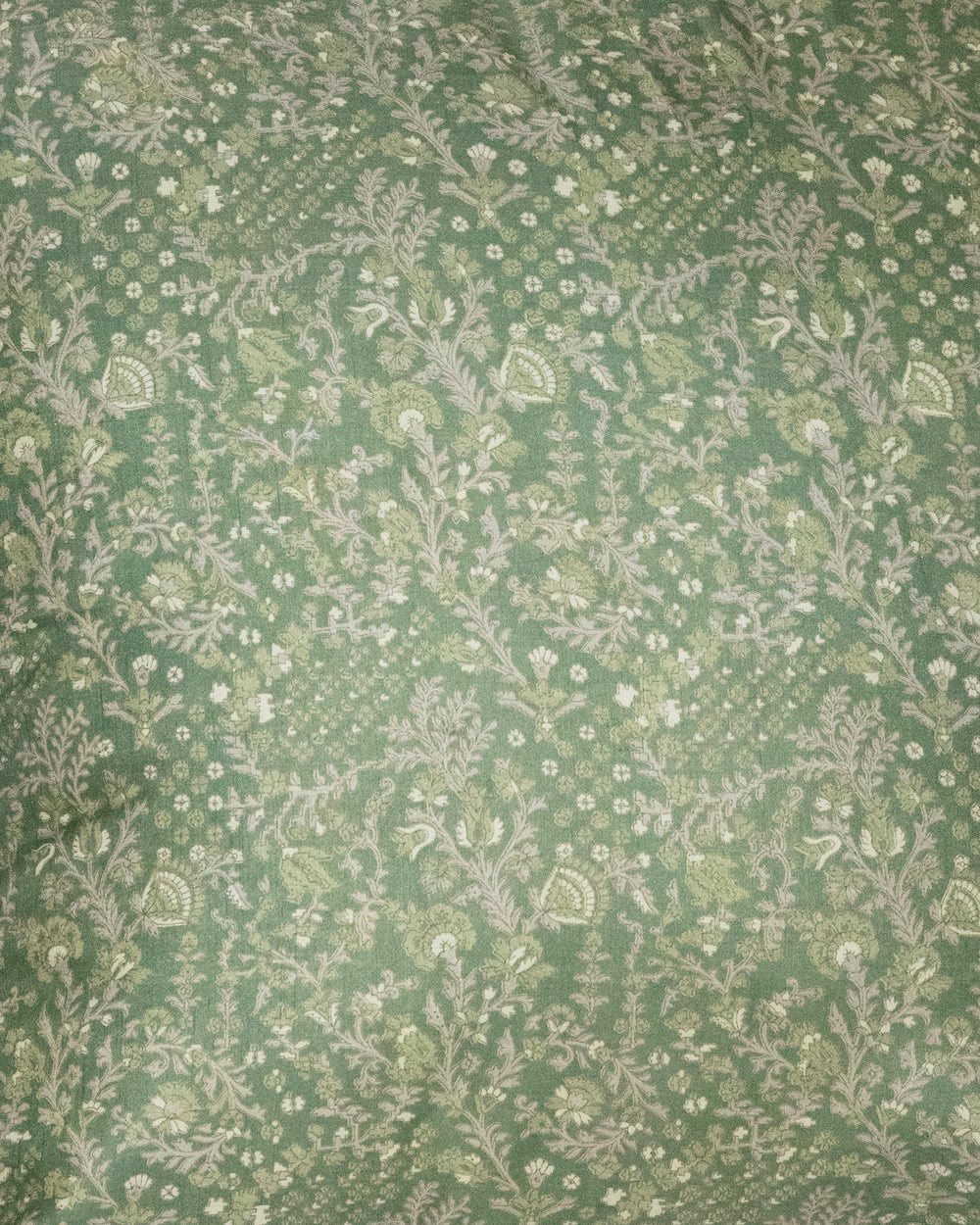 A handcrafted 18x18 pillow cover in a soft green shade, featuring delicate floral and vine patterns in a subtle cream color. The intricate detailing and smooth fabric give the cushion an elegant, nature-inspired look.