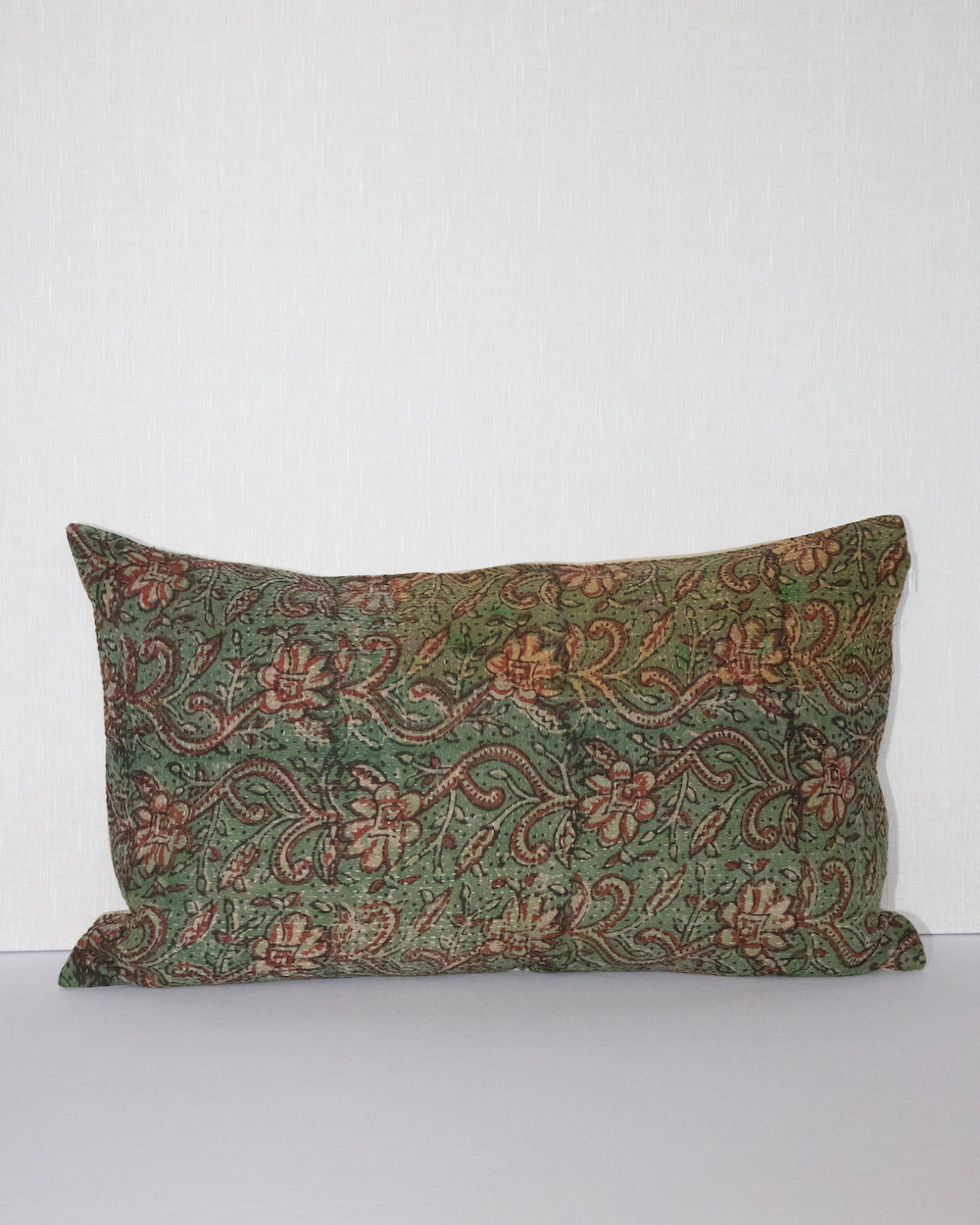 Handcrafted vintage Kantha pillow featuring a green and rust floral block print design, adding bohemian and rustic charm to any room. The rectangular cushion is made from repurposed fabrics, reflecting traditional Indian craftsmanship