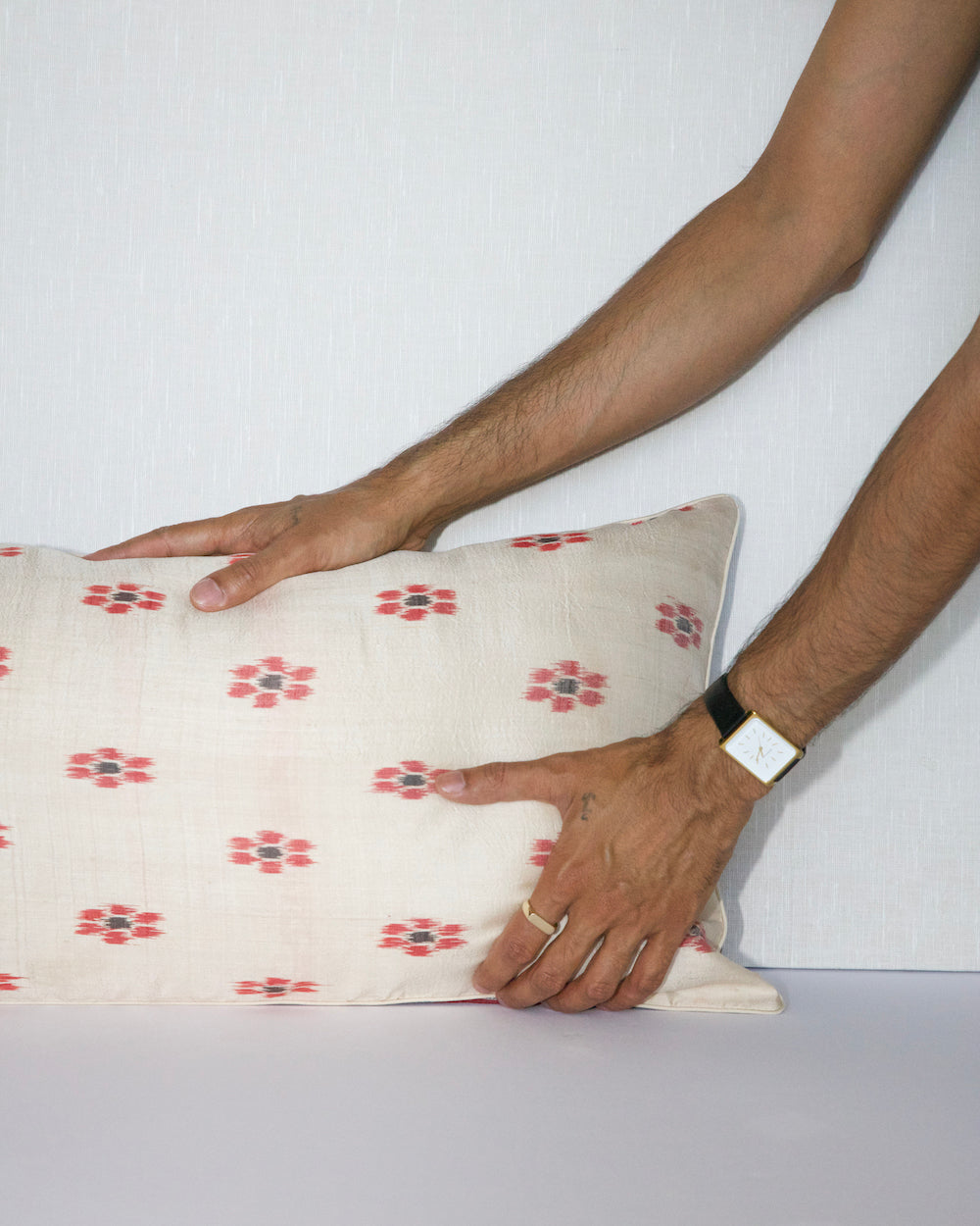 A unique lumbar pillow featuring intricate geometric and floral motifs in warm tones of red, teal, yellow, and beige, set against a black background. The handcrafted design offers a rich, bohemian aesthetic with vintage textile craftsmanship.