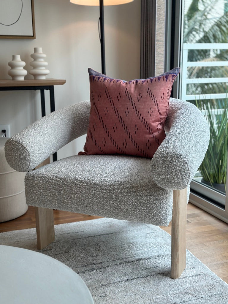 Handcrafted pillow cover made from vintage silk sari fabric in soft peach-pink, featuring ikat-inspired geometric patterns. The 20x20 pillow is one-of-a-kind, showcasing traditional silk weaving techniques with intricate details and luxurious texture