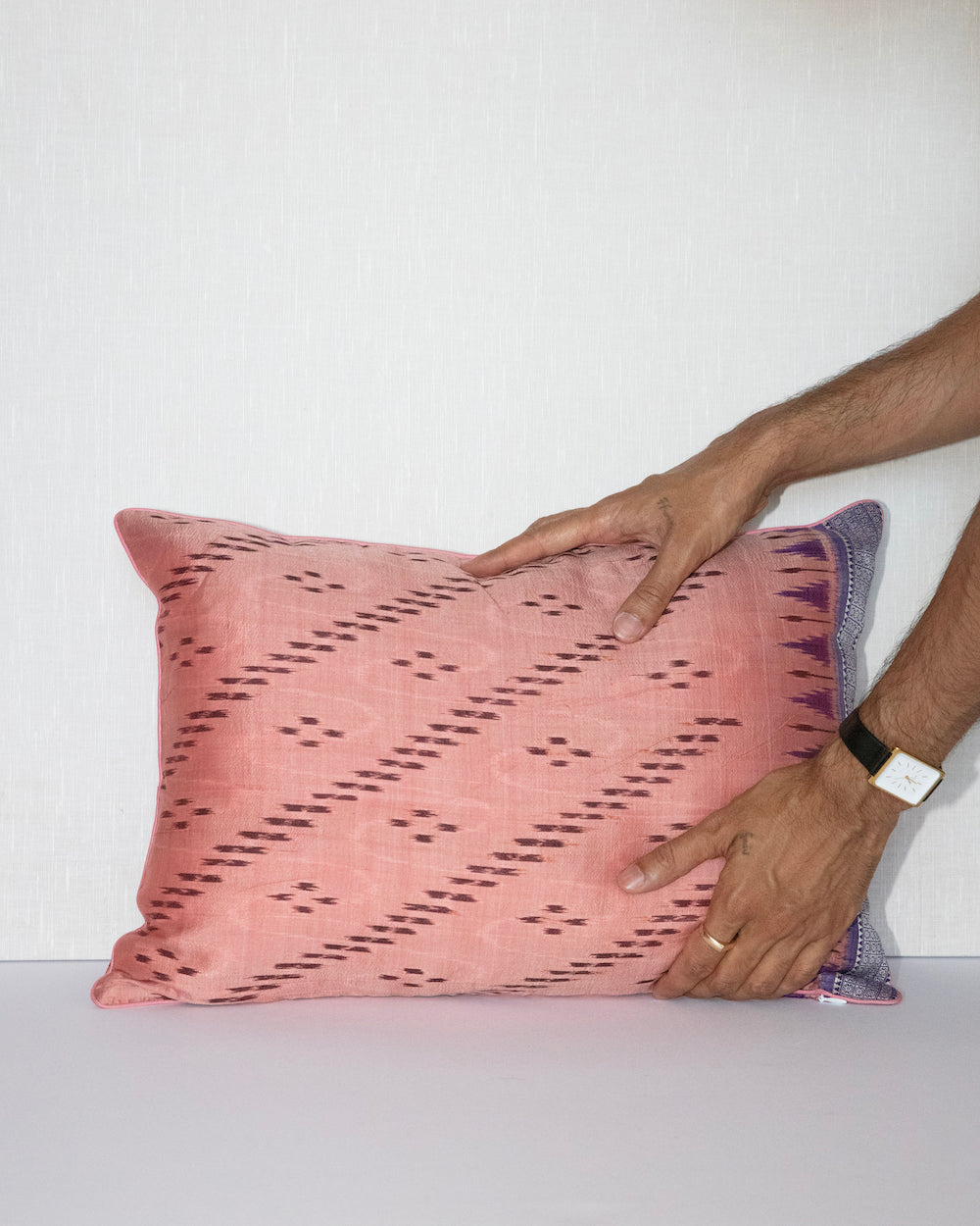 Handcrafted pillow cover made from vintage silk sari fabric in soft peach-pink, featuring ikat-inspired geometric patterns. The 12 x20 pillow is one-of-a-kind, showcasing traditional silk weaving techniques with intricate details and luxurious texture