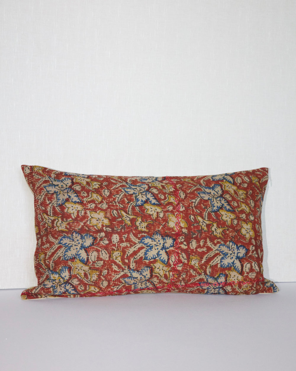 Handcrafted vintage Kantha pillow featuring a rust floral block print design, adding bohemian and rustic charm to any room. The rectangular cushion is made from repurposed fabrics, reflecting traditional Indian craftsmanship