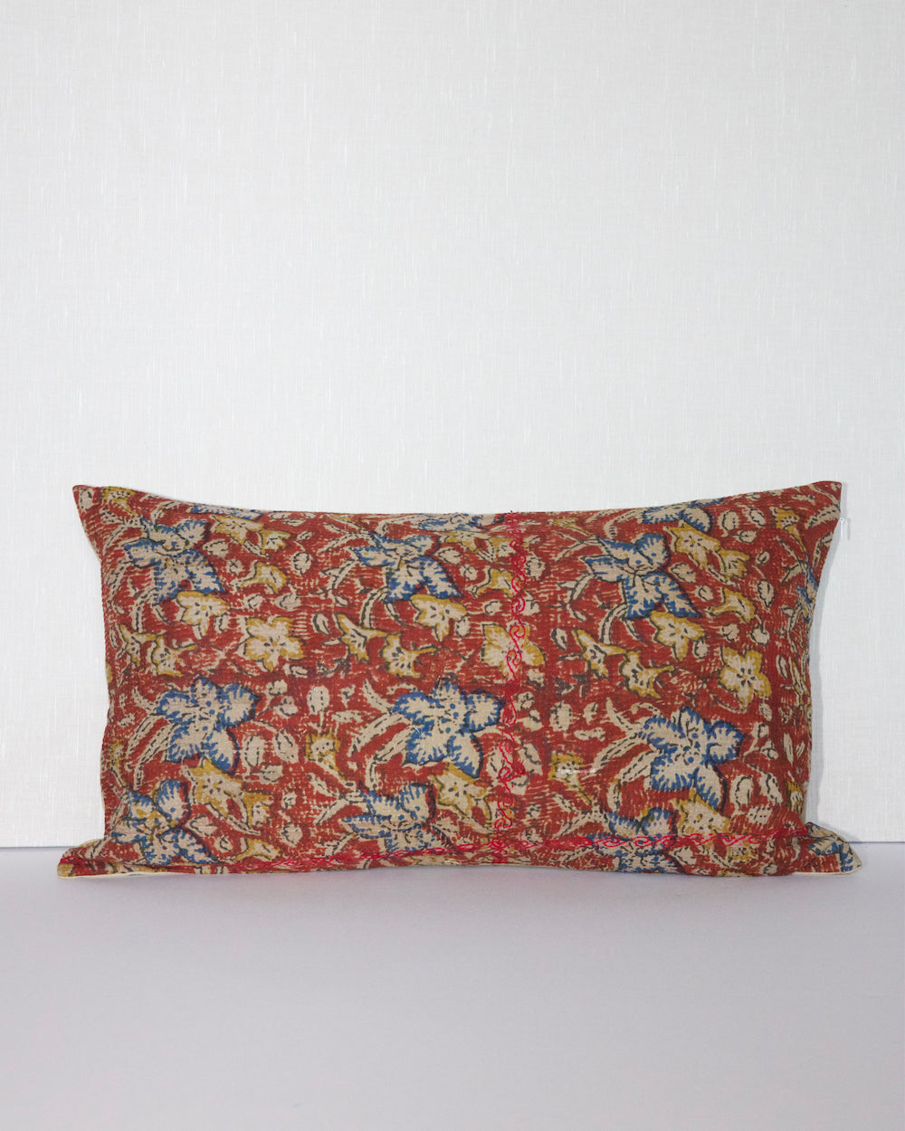 Handcrafted vintage Kantha pillow featuring a rust floral block print design, adding bohemian and rustic charm to any room. The rectangular cushion is made from repurposed fabrics, reflecting traditional Indian craftsmanship