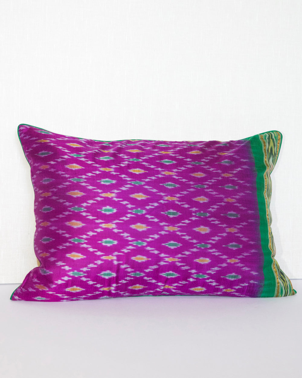 Handcrafted pillow cover made from vintage silk sari fabric in dewberry-pink, featuring ikat-inspired geometric patterns. The 20x20 pillow is one-of-a-kind, showcasing traditional silk weaving techniques with intricate details and luxurious texture