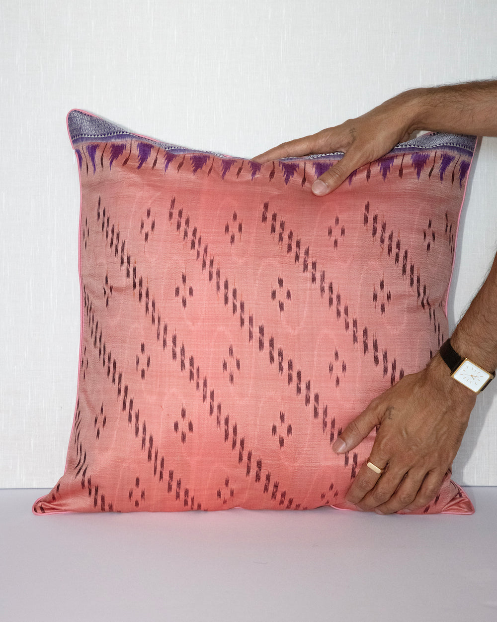 Handcrafted pillow cover made from vintage silk sari fabric in soft peach-pink, featuring ikat-inspired geometric patterns. The 20x20 pillow is one-of-a-kind, showcasing traditional silk weaving techniques with intricate details and luxurious texture