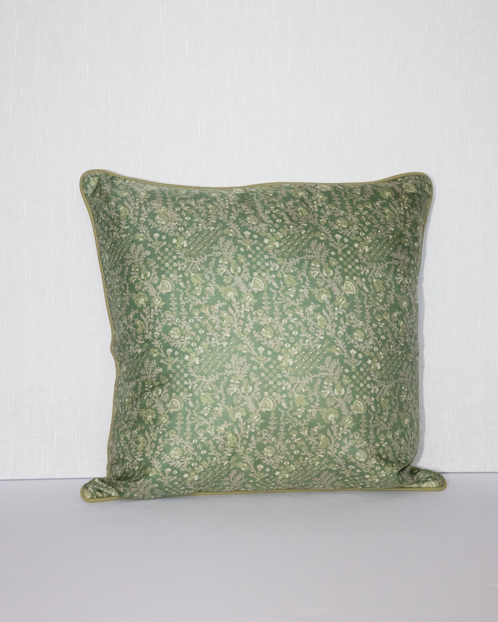 A handcrafted 18x18 pillow cover in a soft green shade, featuring delicate floral and vine patterns in a subtle cream color. The intricate detailing and smooth fabric give the cushion an elegant, nature-inspired look.