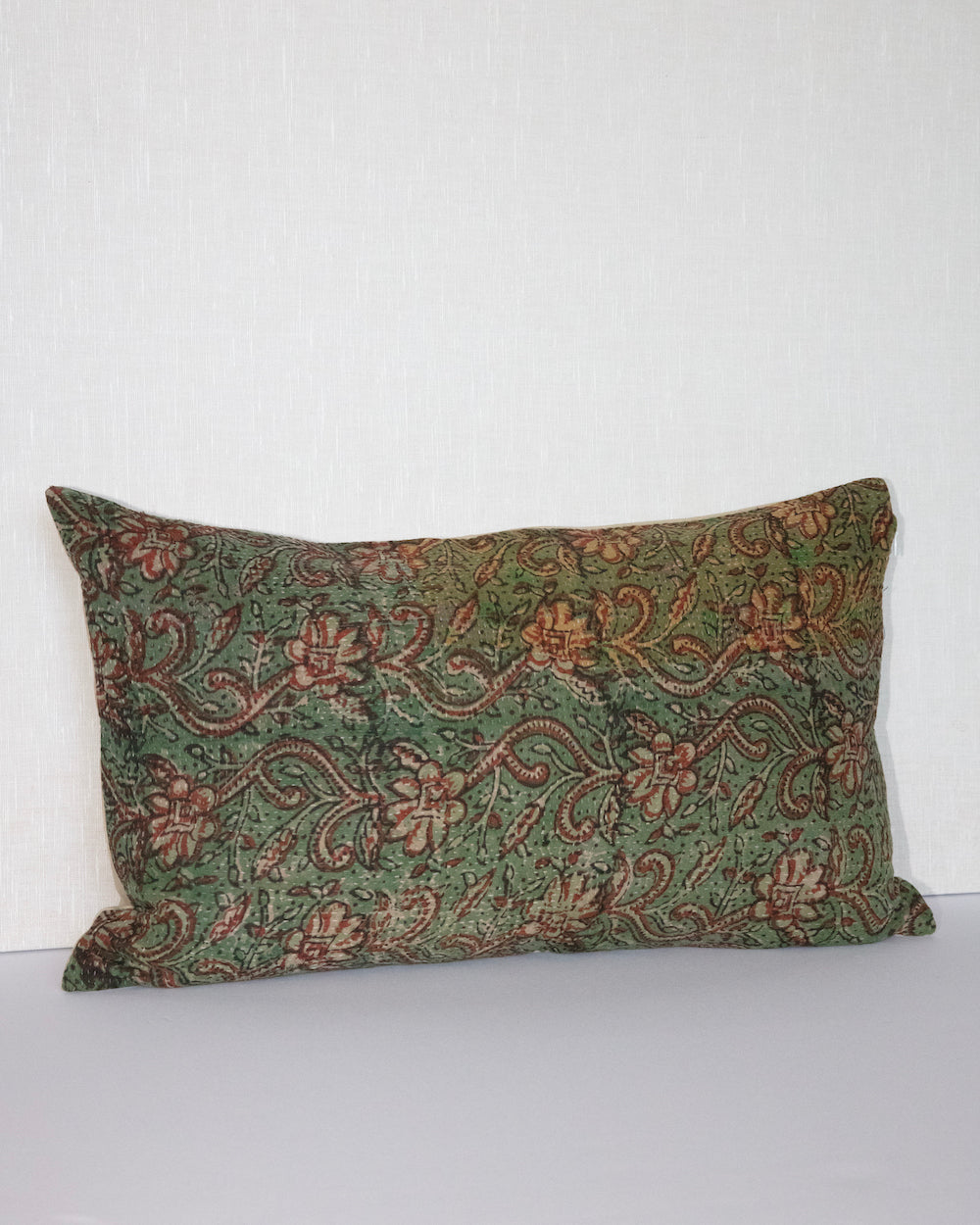 Handcrafted vintage Kantha pillow featuring a green and rust floral block print design, adding bohemian and rustic charm to any room. The rectangular cushion is made from repurposed fabrics, reflecting traditional Indian craftsmanship