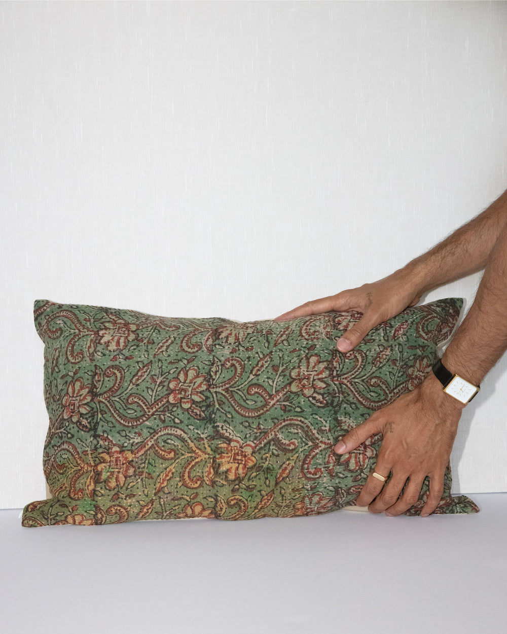 Handcrafted vintage Kantha pillow featuring a green and rust floral block print design, adding bohemian and rustic charm to any room. The rectangular cushion is made from repurposed fabrics, reflecting traditional Indian craftsmanship