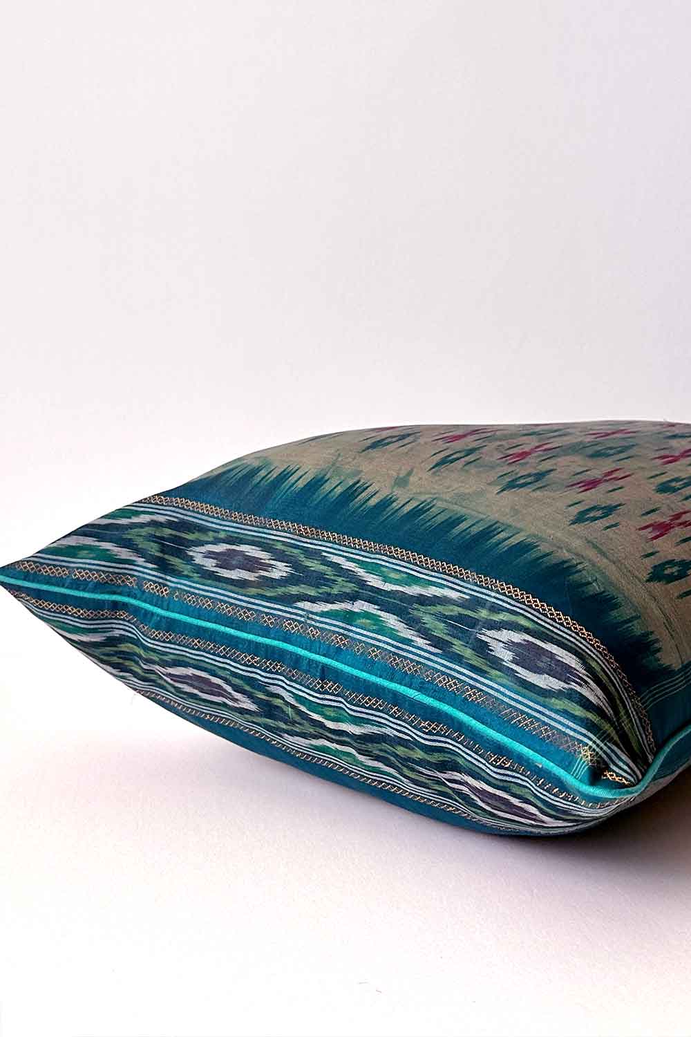 A handcrafted 20x20 pillow cover made from vintage silk fabric, featuring a vibrant ikat pattern in shades of blue and pink. The cushion showcases a unique blend of traditional weaving techniques with a modern, bold color palette.